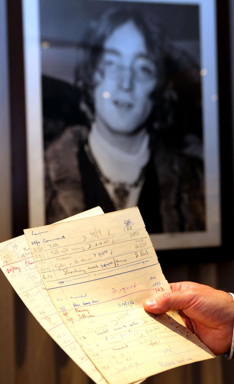 Un empleado de TracksAuction.com con reportes escolares que detallan el mal comportamiento de John Lennon a los 15 a&ntilde;os cuando era estudiante de la Escuela Secundaria Masculina Quarry Bank en Liverpool. Al parecer John Lennon no era un defensor del
