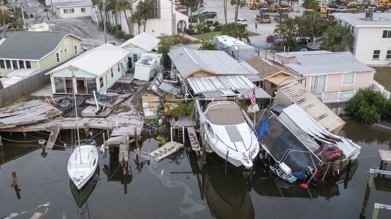 Esta imagen aérea tomada con dron muestra casas dañadas y un vehículo caído al agua tras la marejada ciclónica provocada por el huracán Helene, el sábado 28 de septiembre de 2024 en Madeira Beach, Florida. (Luis Santana/Tampa Bay Times via AP)