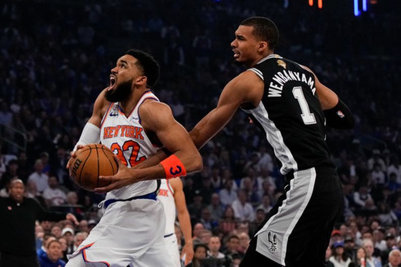 El pívot de los Knicks de Nueva York Karl-Anthony Towns avanza con el balón frente al alero de los Spurs de San Antonio Victor Wembanyama en el juego 4 de las Finales de la NBA el miércoles 10 de junio del 2026. (AP Foto/Ross D. Franklin)