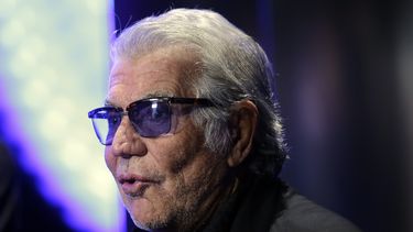 ARCHIVO - El diseñador de moda italiano Roberto Cavalli responde a las preguntas de un reportero de televisión antes del inicio del desfile de la colección para damas Primavera-Verano 2014 de Just Cavalli, parte de la Semana de la Moda de Milán, presentado en Milán, Italia, el 19 de septiembre de 2013. Cavalli, conocido por su estilo extravagante y glamoroso, murió el viernes 12 de abril de 2024 a los 83 años, anunció su compañía en una publicación de Instagram. (Foto AP/Luca Bruno, archivo)