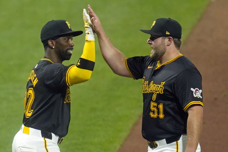 El relevista de los Piratas de Pittsburgh, David Bednar (51), celebra con Andrew McCutchen, a la izquierda, después de sacar el último out de una victoria sobre los Cerveceros de Milwaukee en un juego de béisbol en Pittsburgh, el lunes 22 de abril de 2024. (AP Foto/Gene J. Puskar)
