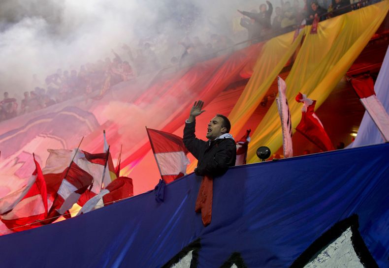 Hinchas del Atl&eacute;tico de Madrid que ocupan la secci&oacute;n del estadio donde se ubica la barra brava "Frente Atl&eacute;tico" animan durante un partido el 23 de febrero de 2012 en el estadio Vicente Calder&oacute;n. (AP Photo/Paul White,