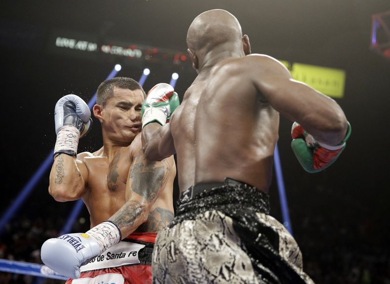 Floyd Mayweather propina un pu&ntilde;etazo al argentino Marcos Maidana, durante su pelea por el t&iacute;tulo, el s&aacute;bado 13 de septiembre de 2014, en Las Vegas (AP Foto/John Locher)