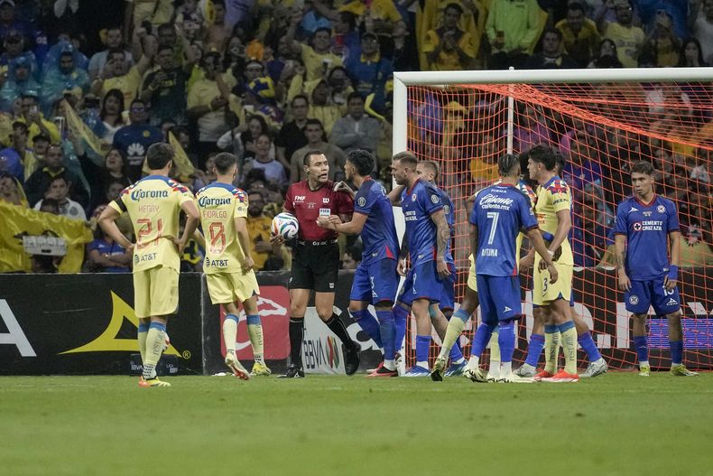 Los jugadores de Cruz Azul discuten con el árbitro Marco Ortiz, quien señaló un penal con el que América se coronó en el torneo Clausura de México en un partido en el estadio Azteca, en Ciudad de México, domingo, mayo 26, 2024. (AP Foto/Eduardo Verdugo)