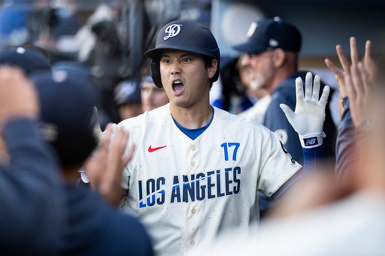 Shohei Ohtani, de los Dodgers de Los Ángeles, celebra su jonrón solitario con la banca durante la primera entrada de un juego de béisbol contra los Rangers de Texas, el sábado 11 de abril de 2026, en Los Ángeles. (Foto AP/Kyusung Gong)