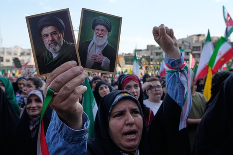 ARCHIVO – Una mujer sostiene imágenes del líder supremo iraní, el ayatolá Moytabá Jamenei, izquierda, y su padre, el asesinado Ali Jamenei, en una marcha organizada por el Estado en Teherán, Irán, el 29 de abril de 2026. (AP Foto/Vahid Salemi, Archivo)
