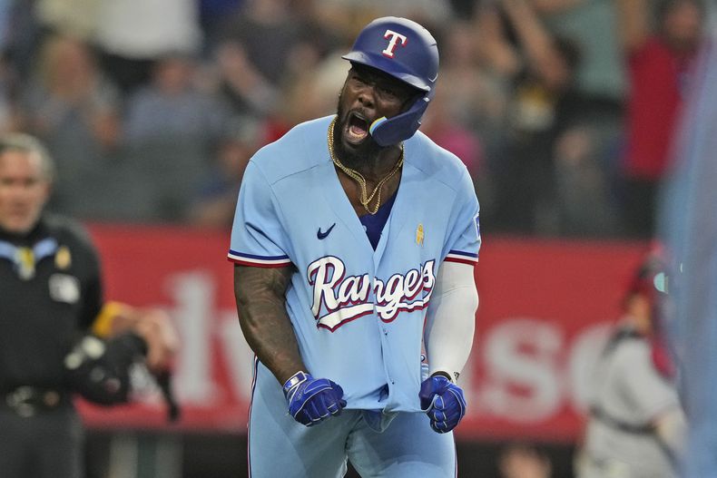 Adolis García, de los Rangers de Texas, reacciona después de batear un cuadrangular solitario durante la novena entrada del juego de béisbol en contra de los Mellizos de Minnesota, en Arlington, Texas, el domingo 3 de septiembre de 2023. (AP Foto/LM Otero)
