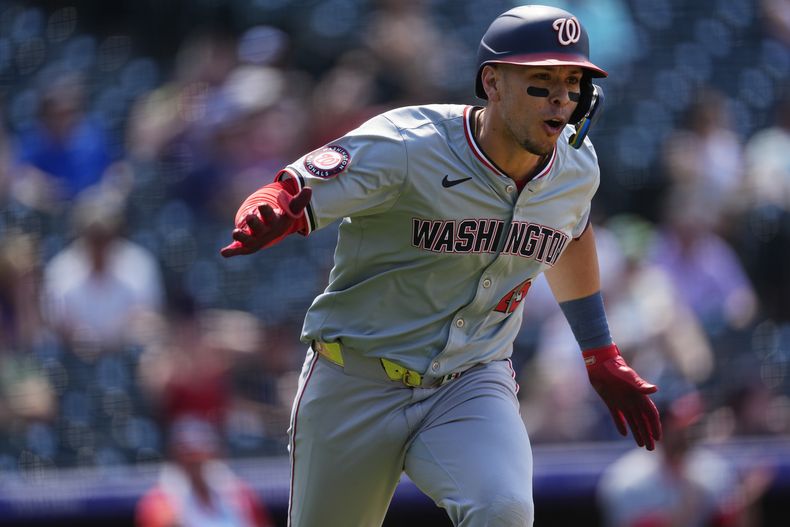 El mexicano de los Nacionales de Washington, Joey Meneses reacciona al dirigirse hacia la primera base luego de impulsar la carrera de la ventaja con un sencillo ante el relevista de los Rockies de Colorado, Jalen Beeks, en el noveno episodio del juego de béisbol, el domingo 23 de junio de 2024, en Denver. (AP Foto/David Zalubowski)