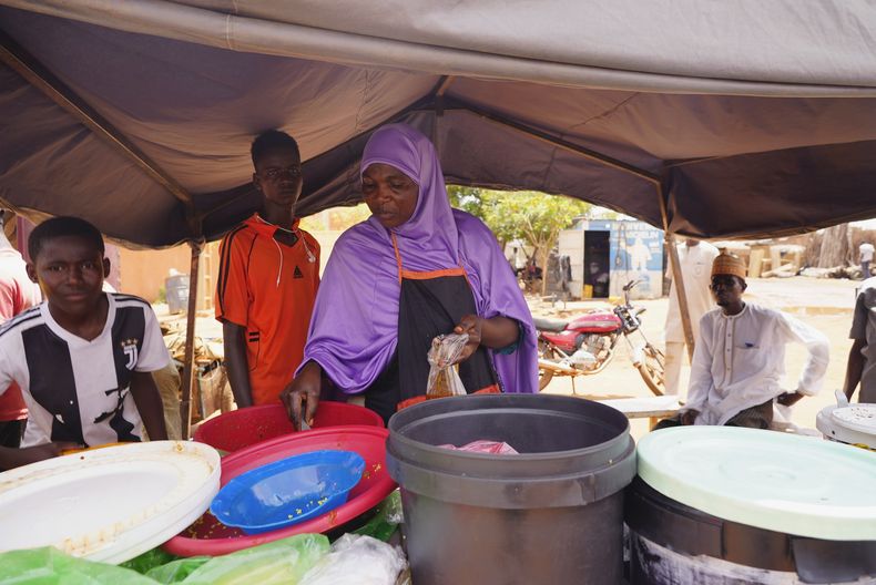 Una mujer prepara comida en Niamey, Níger, el sábado 29 de julio de 2023. La Unión Africana ha emitido un ultimátum de 15 días a la junta militar en Níger para reinstalar el gobierno elegido democráticamente del país. (AP Foto/Sam Mednick)