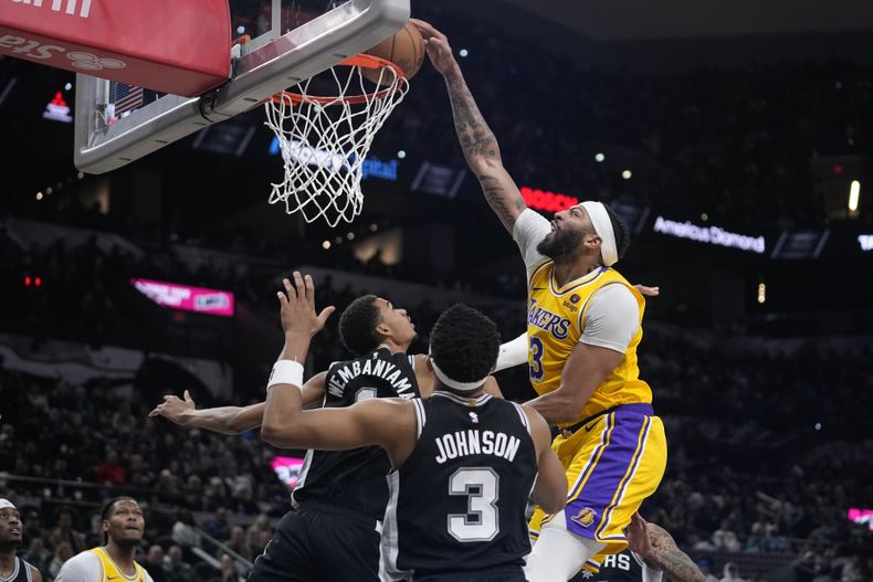 Anthony Davis, alero de los Lakers de Los Ángeles, anota frente al pívot francés Victor Wembanyama, de los Spurs de San Antonio, en el partido del miércoles 13 de diciembre de 2023 (AP Foto/Eric Gay)