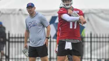 Joe Brady, izquierda, head coach de los Bills de Buffalo, observa al quarterback Josh Allen (17) mientras lanza el balón durante la práctica del equipo en el campamento de entrenamiento, el miércoles 29 de julio de 2026, en Pittsford, Nueva York. (AP Foto/Adrian Kraus)