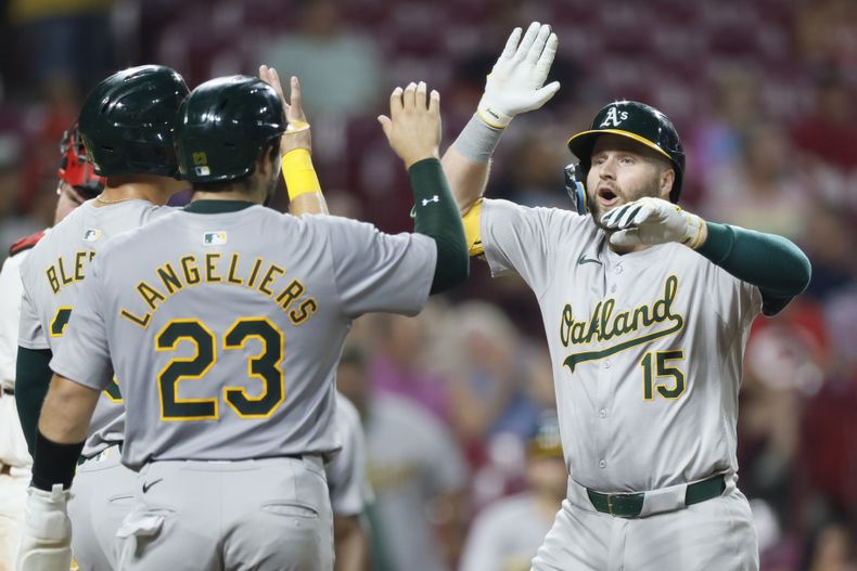 Seth Brown (derecha), de los Atléticos de Oakland, festeja su jonrón ante los Rojos de Cincinnati, en el juego del miércoles 28 de agosto de 2024 (AP Foto/Jay LaPrete)