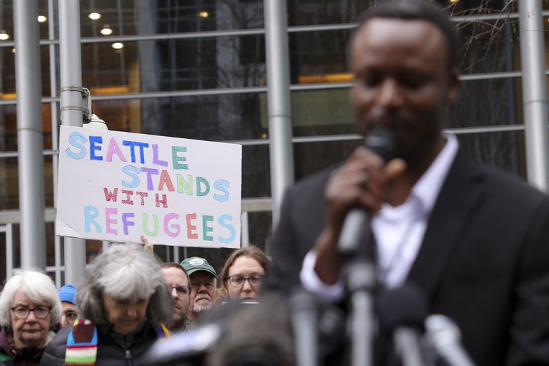 Una persona muestra un cartel de apoyo a los refugiados durante la intervención de Tshishiku Henry, un antiguo refugiado y delegado de Refugee Congress para el estado de Washington, en un mitin en el exterior de la Corte de Distrito de Estados Unidos luego de que un juez federal bloqueó una iniciativa de Donald Trump para suspender el programa de admisiones de refugiados del país, el 25 de febrero de 2025 en Seattle. (AP Foto/Ryan Sun)