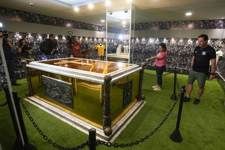 Aficionados parados juntos a la tumba del exfutbolista brasileño Pelé en el Mausoleo construido en el Cementerio Necropole Ecumenica Memorial en Santos, Brasil el lunes 15 de mayo del 2023. (AP Foto/Andre Penner)