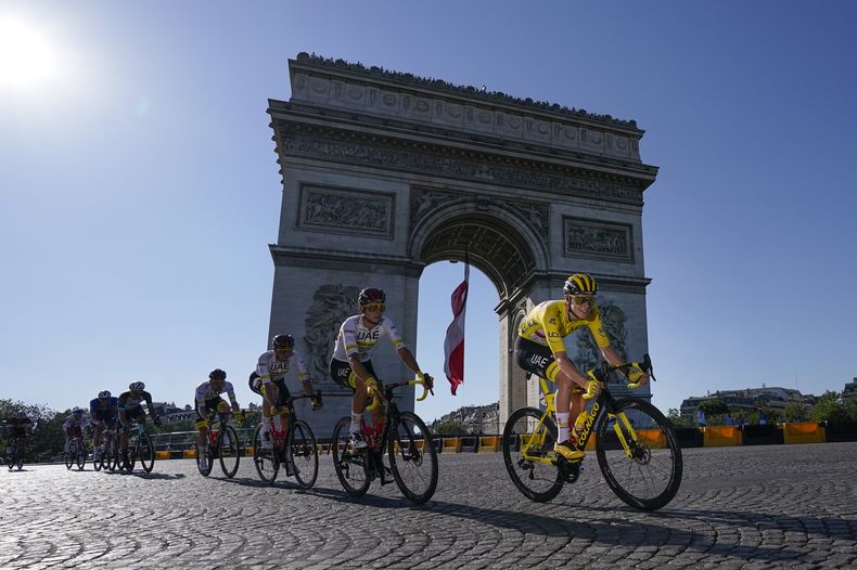 ARCHIVO - Tadej Pogacar, con la casaca amarilla de líder general, pasa por el Arco del Triunfo de París, durante la 21ra etapa del Tour de Francia, el 18 de julio de 2021. (AP Foto/Daniel Cole)