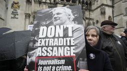 Una manifestante sostiene una pancarta frente a los Tribunales Reales de Justicia en Londres, el 21 de febrero de 2024, en apoyo al fundador de WikiLeaks, Julian Assange. (Foto AP/Kin Cheung, archivo)