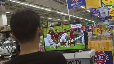 americateve | Un comprador tailand&eacute;s observa un partido de f&uacute;tbol transmitido por televisi&oacute;n en un centro comercial de Bangkok, el jueves 11 de junio de 2014. La junta militar de Tailandia anunci&oacute; que pagar&aacute; una compensaci&oacute;n al