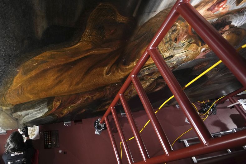 La restauradora de arte Jantine Maessens trabaja en una sección de la pintura Madona entronizada con niño, rodeada de santos del artista flamenco Peter Paul Rubens, en el Museo Real de Bellas Artes de Amberes, Bélgica, el martes 28 de enero de 2025. (Foto AP/Virginia Mayo)