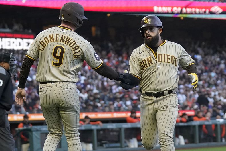 Jake Cronenworth, de los Padres de San Diego, festeja con el venezolano Rougned Odor, después de que ambos anotaron en el juego del 19 de junio de 2023, ante los Gigantes de San Francisco (AP Foto/Jeff Chiu)