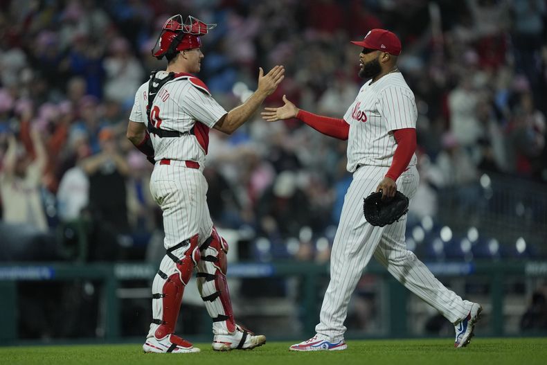 El receptor de los Filis de Filadelfia J.T. Realmuto (izquierda) y el lanzador venezolano José Alvarado celebran el triunfo ante los Gigantes de San Francisco, el domingo 5 de mayo de 2024, en Filadelfia. (AP Foto/Matt Rourke)