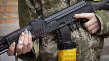 ARCHIVO - Una mujer armada de la defensa civil sostiene un rifle de asalto Kalashnikov mientras patrulla una calle vacía debido a un toque de queda en Kyiv, Ucrania, 27 de febrero de 2022. Estados Unidos ha transferido a Ucrania 1,1 millones de cartuchos de munición para armas ligeras que incautó a Irán, informó el miércoles el Mando Central estadounidense. (AP Foto/Efrem Lukatsky, File)