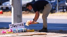 Un hombre coloca flores cerca del lugar donde un venezolano fue baleado por un agente del ICE el día anterior en Austin, Texas, lunes 21 de septiembre de 2026. (Foto AP/Eric Gay)