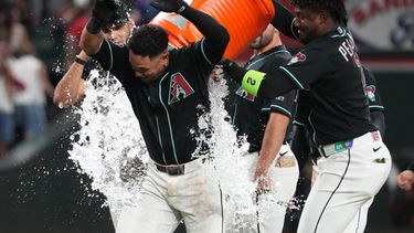 El venezolano Ildemaro Vargas, de los Diamondbacks de Arizona, es empapado por su compañero, el dominicano Geraldo Perdomo, luego de resolver con un sencillo el duelo ante los Atléticos, el martes 21 de julio de 2026 (AP Foto/Rick Scuteri)