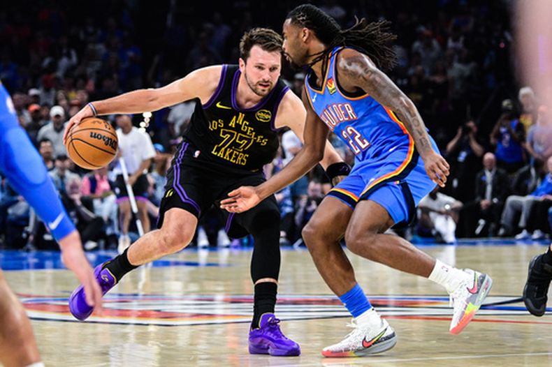 Luka Doncic (77) de los Lakers de Los Ángeles se desmarca frente a Cason Wallace del Thunder de Oklahoma City, el jueves 2 de abril de 2026, en Oklahoma City. (AP Foto/Gerald Leong)