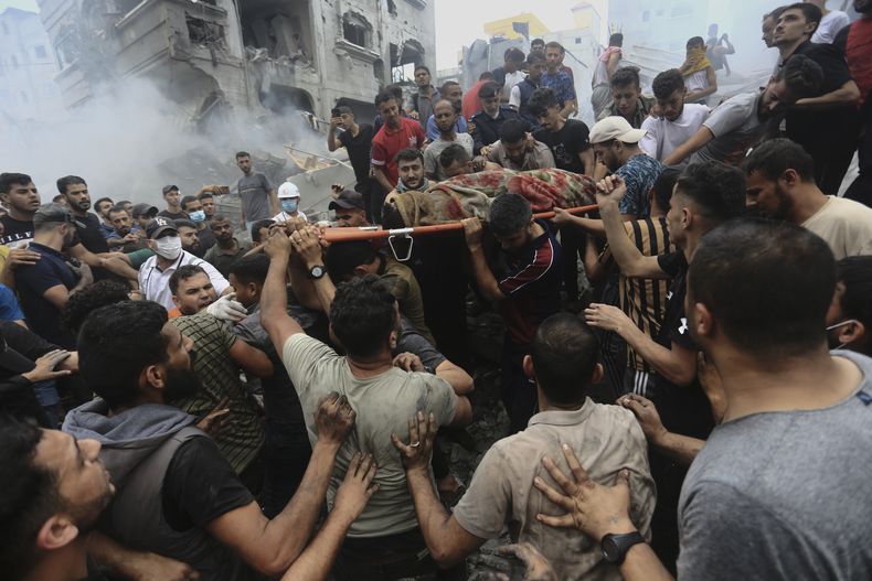 Palestinos retiran un cuerpo de entre los escombros de un edificio tras un ataque aéreo israelí al campo de refugiados Jebaliya, en la Franja de Gaza, el 9 de octubre de 2023. (AP Foto/Ramez Mahmoud)