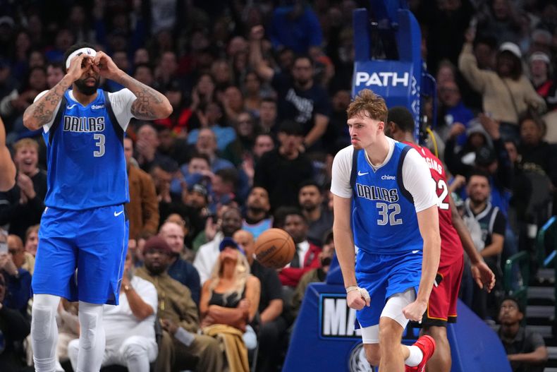 Cooper Flagg (32) y Anthony Davis, de los Mavericks de Dalls, festejan un enceste en el partido ante el Heat de Miami, el miércoles 3 de diciembre de 2025 (AP Foto/Julio Cortez)