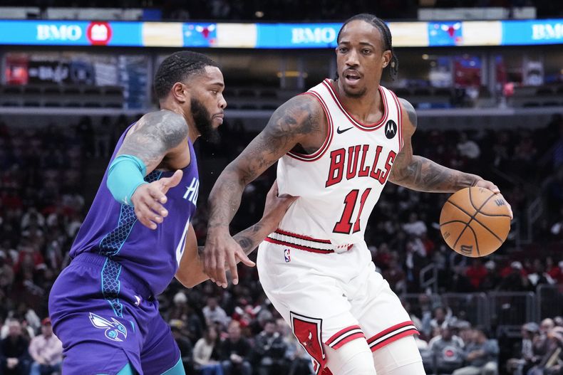 El alero de los Bulls de Chicago, DeMar DeRozan, derecha, conduce el balón con la presión de Miles Bridges, de los Hornets de Charlotte, durante la primera mitad del juego de baloncesto de la NBA, en Chicago, el miércoles 6 de diciembre de 2023. (AP Foto/Nam Y. Huh)