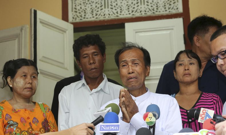 Tun tun Htike, padre de un inmigrante de Mianmar arrestado, Win Zaw Htun, habla con la prensa mientras Thing Shwe Aug, izq., Phu Shwe Nusegundo de la izquierda, padrees de Zaw Lin  y May Thein , madre de Win Zaw Htun escuchan en la embajada de Mianmar en