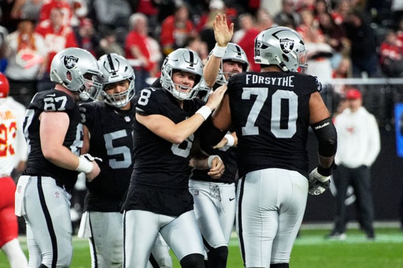 Daniel Carlson (8), de los Raiders de Las Vegas, es felicitado por sus compañeros de equipo después de acertar un gol de campo de 60 tardas en los últimos segundos del partido de la NFL en contra de los Chiefs de Kansas City, el domingo 4 de enero de 2026, en Las Vegas. (AP Foto/John Locher)