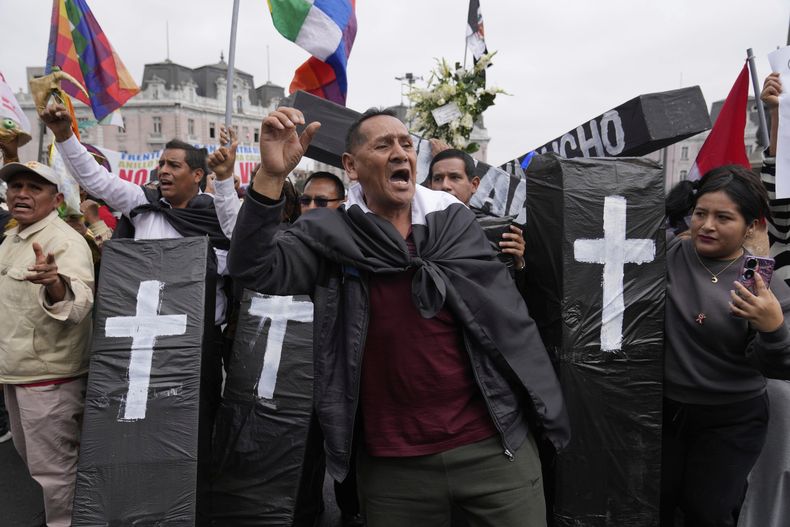 Un grupo de personas porta ataúdes de cartón en representación de sus parientes muertos por violencia política en el centro de Lima, Perú, el lunes 28 de julio de 2025, en una protesa contra la presidenta Dina Boluarte mientras pronuncia su duiscurso anual ante el Congreso. (AP Foto/Martín Mejía)