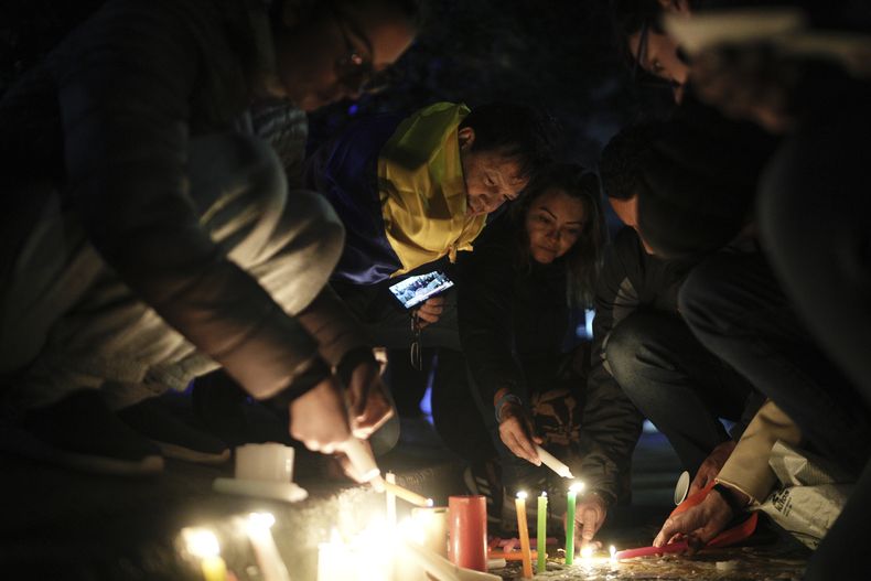 Personas encienden velas durante una vigilia frente a un hospital de Santa Fe, donde el senador y candidato presidencial colombiano Miguel Uribe Turbay recibe atención médica tras recibir disparos durante un mitin de campaña en Bogotá, Colombia, el sábado 7 de junio de 2025. (Foto AP/Iván Valencia)