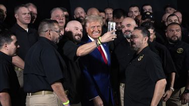 El candidato presidencial republicano Donald Trump sonríe para una selfie con miembros de la Patrulla Fronteriza de Estados Unidos antes de hablar en un mitin de campaña, el domingo 13 de octubre de 2024, en Prescott Valley, Arizona. (AP Foto/Evan Vucci)
