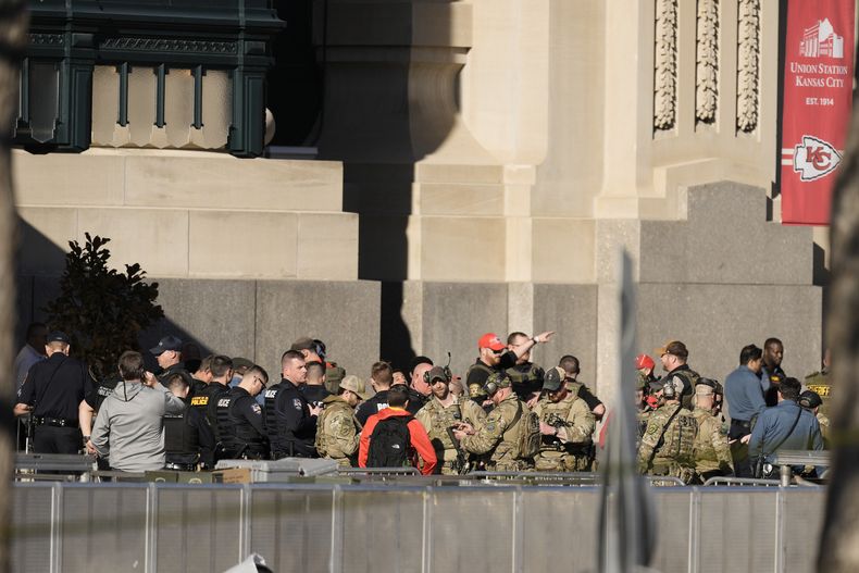 Oficiales de policía tienen una conversación en el lugar del tiroteo durante el desfile de los Chiefs de Kansas City tras su victoria en el Super Bowl el miércoles 14 de febrero del 2024. (AP Foto/Charlie Riedel)