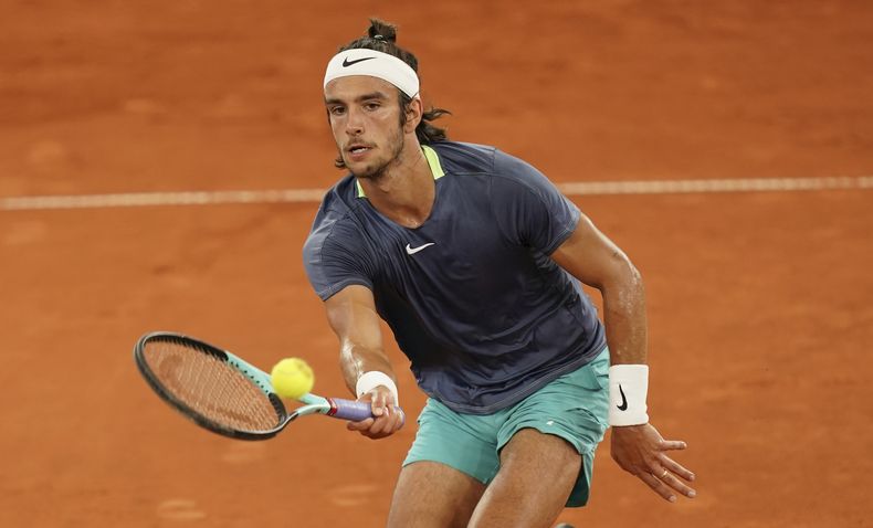 El italiano Lorenzo Musetti hace una devolución al eslovaco Jozef Kovalik durante el torneo de Hamburgo, el jueves 27 de julio de 2023 (Marcus Brandt/dpa via AP)