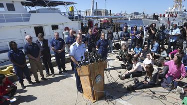 El contraalmirante John Mauger, comandante del Primer Distrito de la Guardia Costera, al centro, habla con la prensa el jueves 22 de junio de 2023, en la Base Boston de la Guardia Costera, en Boston. (AP Foto/Steven Senne)