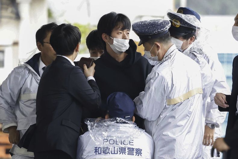 Ryuji Kimura, centro, es detenido por la policía después que arrojó una bomba casera hacia el ex primer ministro de Japón Fumio Kishida durante un mitin de campaña en Wakayama, Japón, el 15 de abril de 2023. (Kyodo News vía AP)