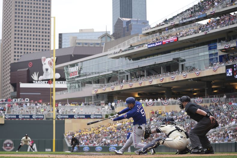 Corey Seager (5), de los Rangers de Texas, dispara jonrón de dos carreras durante la tercera entrada del juego de béisbol en contra de los Mellizos de Minnesota, el domingo 26 de mayo de 2024, en Minneapolis. (AP Foto/Abbie Parr)