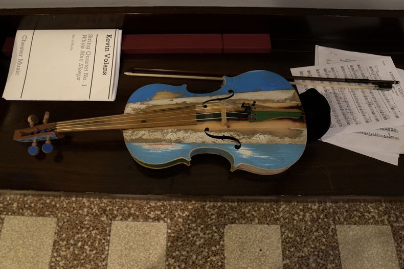 Un violín hecho con madera de barcos de inmigrantes durante un ensayo en Milán en el norte de Italia el sábado 10 de febrero de 2024. Reclusos de la cárcel de máxima seguridad Opera usan madera de los botes de inmigrantes para crear instrumentos musicales que la Orquesta del Mar tocó en su debut en el Teatro alla Scala. (Foto AP/Antonio Calanni)