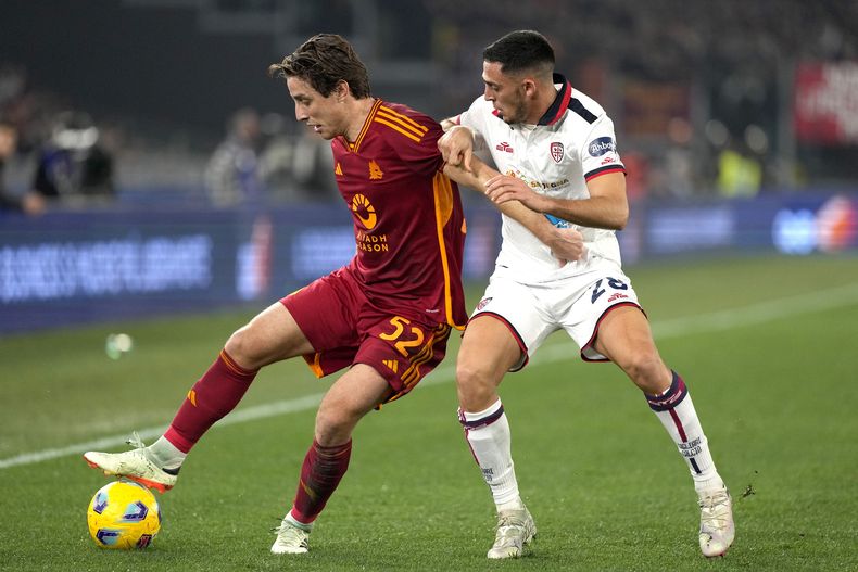 Edoardo Bove de la Roa y Gabriele Zappa del Cagliari pelean por el balón en el encuentro de la Serie A en el Estadio Olímpico el lunes 5 de febrero del 2024. (AP Foto/Andrew Medichini)