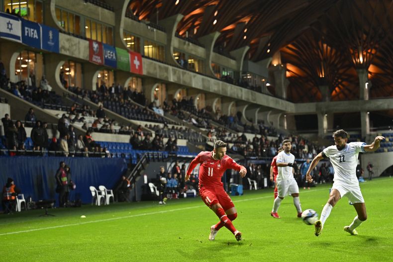 Ofir Davidzada (derecha), de la selección de Israel, trata de tapar un centro de Renato Steffen, de Suiza, durante un partido de la eliminatoria a la Eurocopa, realizado el miércoles 15 de noviembre de 2023 en Felcsut, Hungría (AP Foto/Denes Erdos)