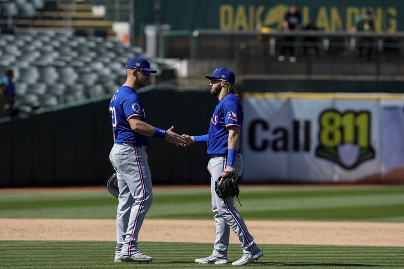 El primera base de los Texas Rangers, Nathaniel Lowe, izquierda, y el tercera base Davis Wendzel celebran después de la victoria del equipo sobre los Atléticos de Oakland en el partido de béisbol el martes 7 de mayo de 2024 en Oakland, California (Foto AP/Godofredo A. Vásquez)