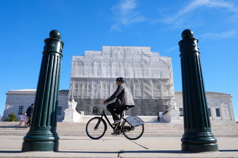 Una persona pasa en bicicleta frente a la construcción que se realiza en el frente de la Corte Suprema de Estados Unidos, el lunes 24 de noviembre de 2025, en Washington. (AP Foto/Mariam Zuhaib)