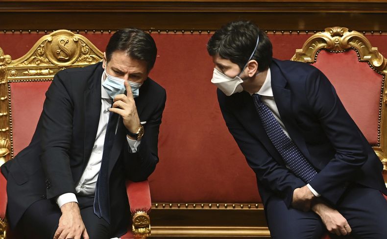 ARCHIVO - El entonces premier Giuseppe Conte, izquierda, habla con el ministro de Salud, Roberto Speranza, en el Senado, Roma 19 de enero de 2021. La corte de ministros de Brescia desestimó la denuncia contra el entonces premier Giuseppe Conte y el ministro de Salud, Roberto Speranza, de que no extendieron la cuarentena a Bergamo y los valles aledaños en los primeros tiempos de la pandemia de coronavirus, lo que causó muertes innecesarias. (Andreas Solaro/Pool via AP)