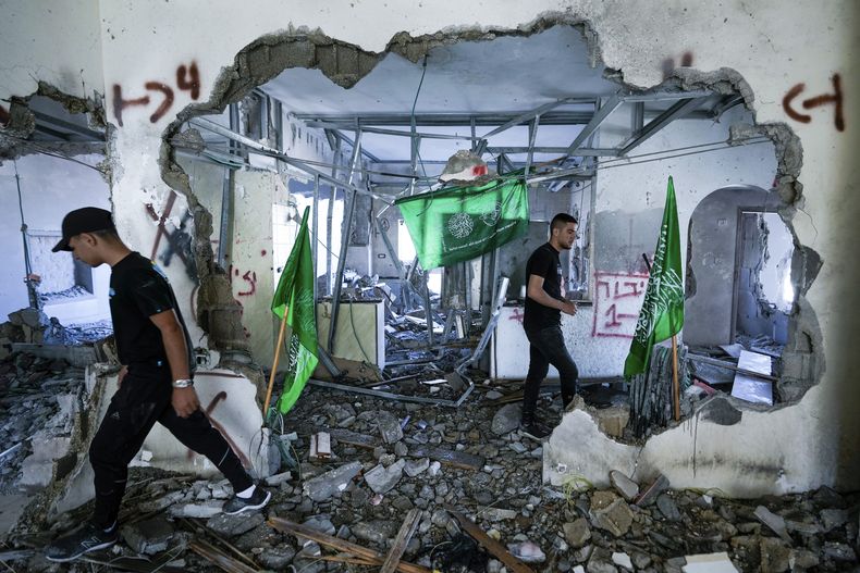 Palestinso revisan las ruinas de la casa de un miliciano de Hamas demolida por tropas israelíes en Naalin, un pueblo de Cisjordania, el martes 23 de mayo de 2023. Era la casa de Moataz Khawaja, de 23 años, al que el ejército israelí identificó como responsable de un ataque con un muerto y dos heridos en Tel Aviv el pasado mes de marzo. Hamas ha dicho que Khawaja era miembro de su brazo armado. (AP Foto/Majdi Mohammed)