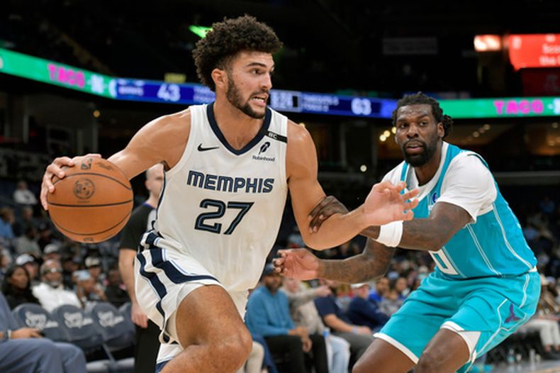 El alero de los Grizzlies de Memphis Cameron Boozer avanza con el balón mientras lo defiende el pívot de los Hornets de Charlotte Naz Reid en el encuentor de pretemporada del viernes 16 de octubre del 2026. (AP Foto/Brandon Dill)