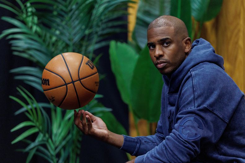 El base de los Clippers de Los Ángeles Chris Paul posa con un balón durante el día de medios del equipo el lunes 29 de septiembre del 2025. (AP Foto/Eric Thayer)